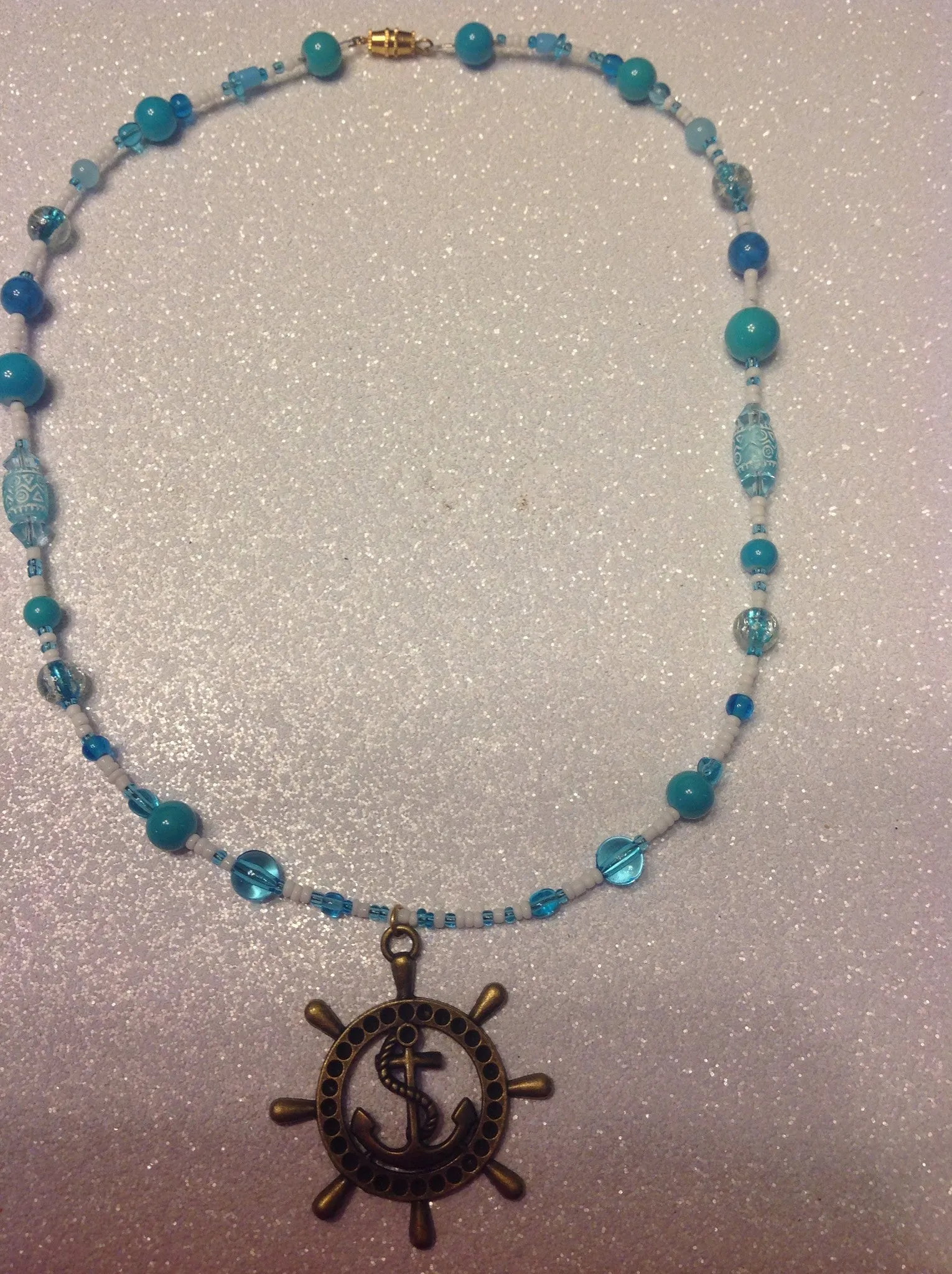 Teal and white beaded ships wheel necklace.